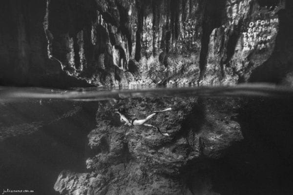 underwater photography of girl in cave
