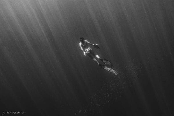 underwater photography of girl swimming