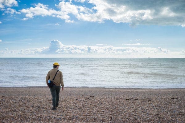 Man walking at Brighton Beach, England