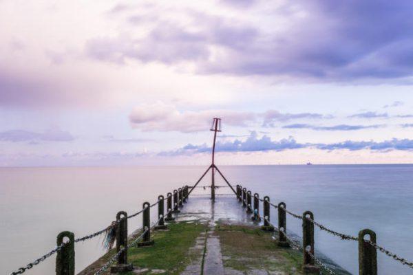 Colour pier with purple sunrise at the ocean