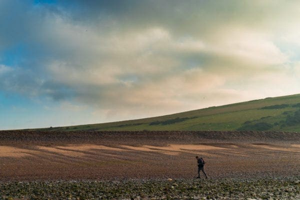 Man Hiking over English Countryside at sunrise
