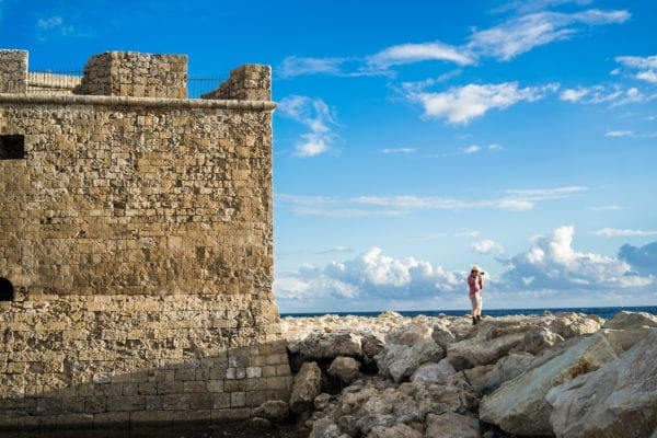 Paphos Castle with photographer standing near the ocean
