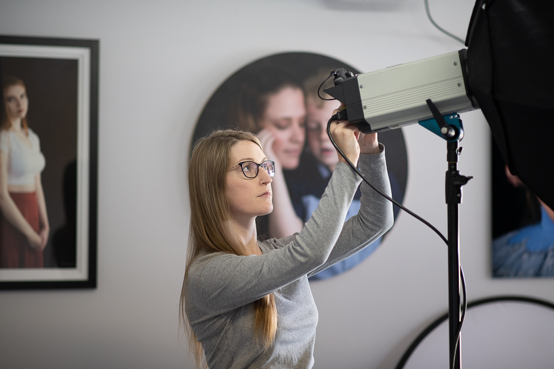 Julia Nance in her professional headshot photography studio, adjusting studio lighting