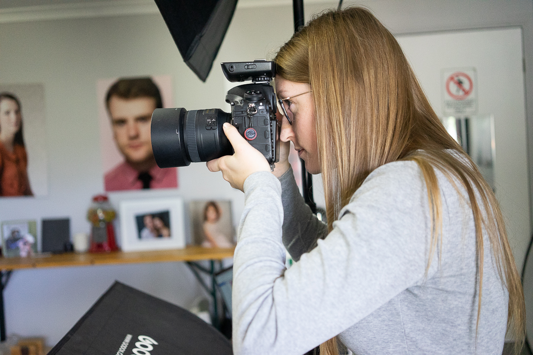 Julia Nance in her professional headshot photography studio, looking through her camera
