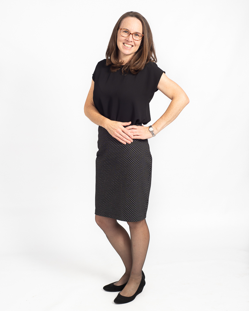 Corporate portrait of woman on white background, posed in a professional business dress.