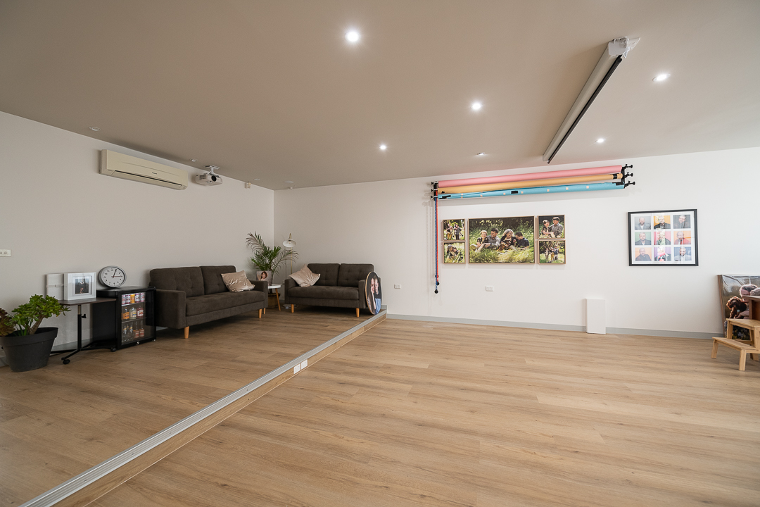 Interior image of the Julia Nance Portraits studio in Ringwood East. You can see couches, artwork and coloured backgrounds.