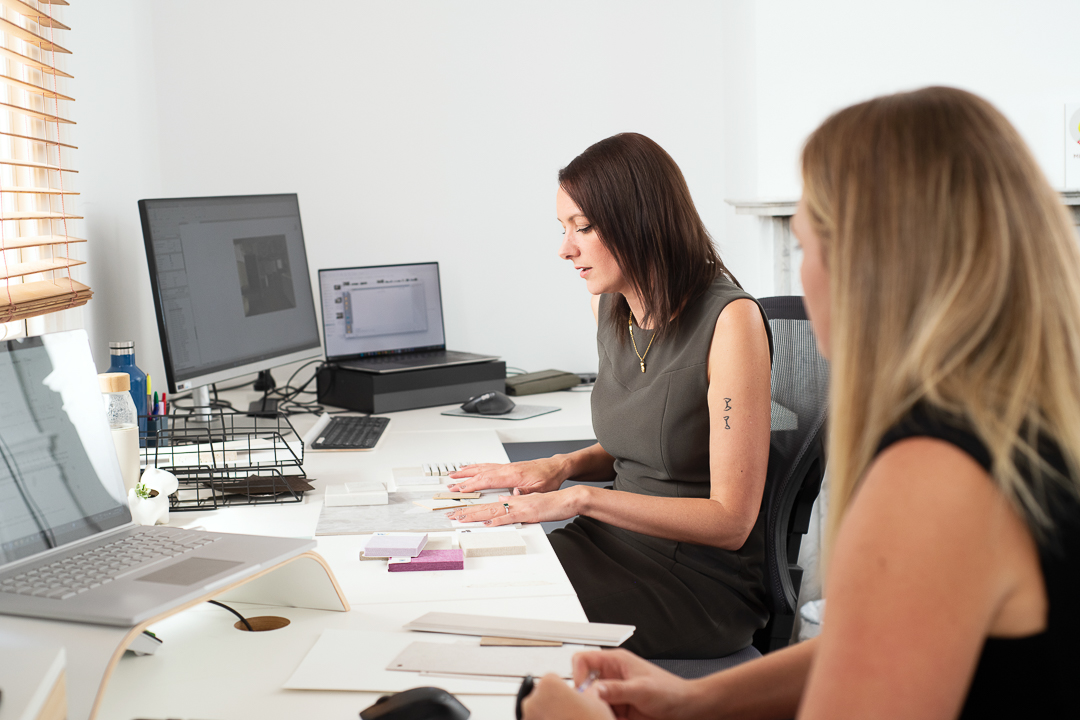 A personal branding staff in-situ photograph of two women working at their desks in their workplace.