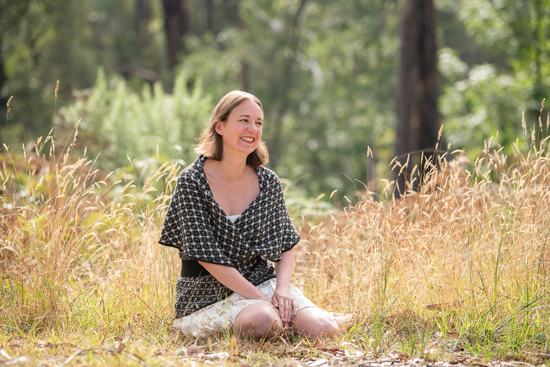 Melbourne business woman smiles and looks away from the camera while outdoors for personal branding headshot.