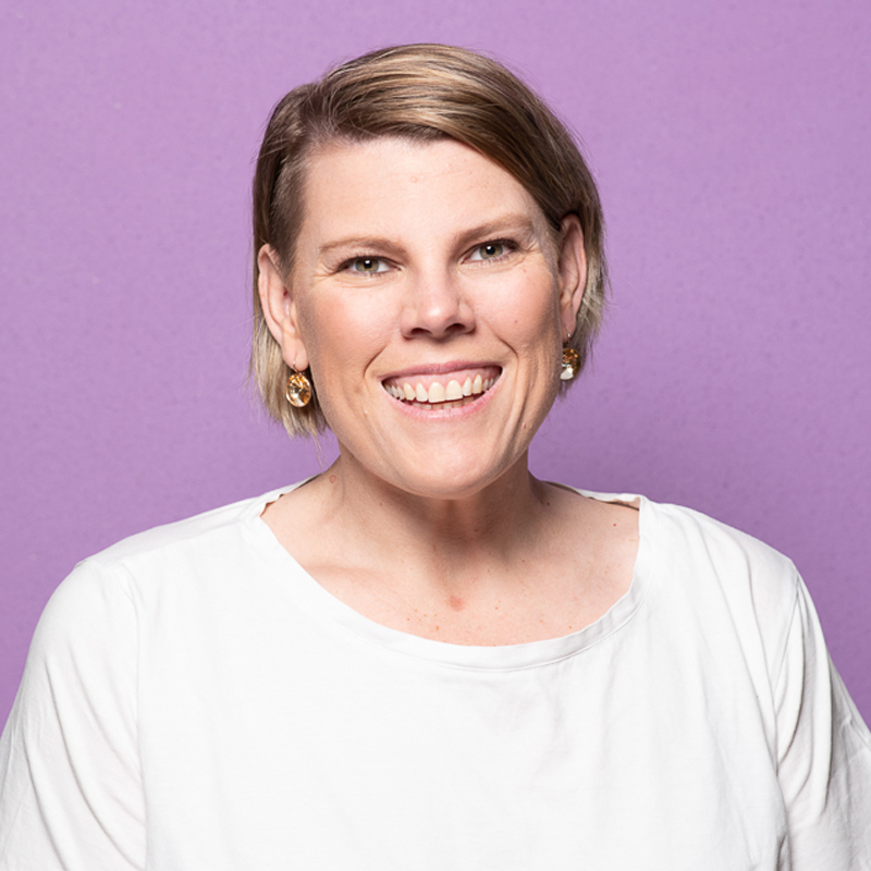 Melbourne LinkedIn headshot with natural smile and colourful purple background.