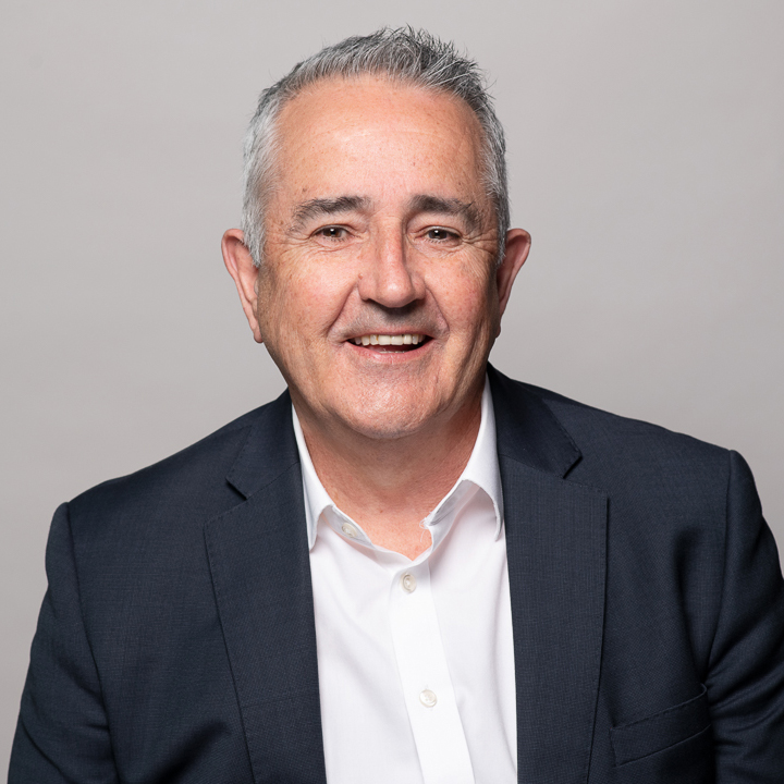 Melbourne LinkedIn headshot for local barrister, who is smiling with teeth in a relaxed manner. He wears a navy blazer and white shirt with no tie.