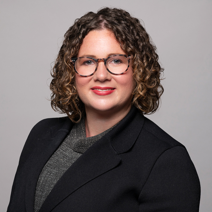 Melbourne LinkedIn headshot for local barrister, wearing professional black attire and wearing glasses.