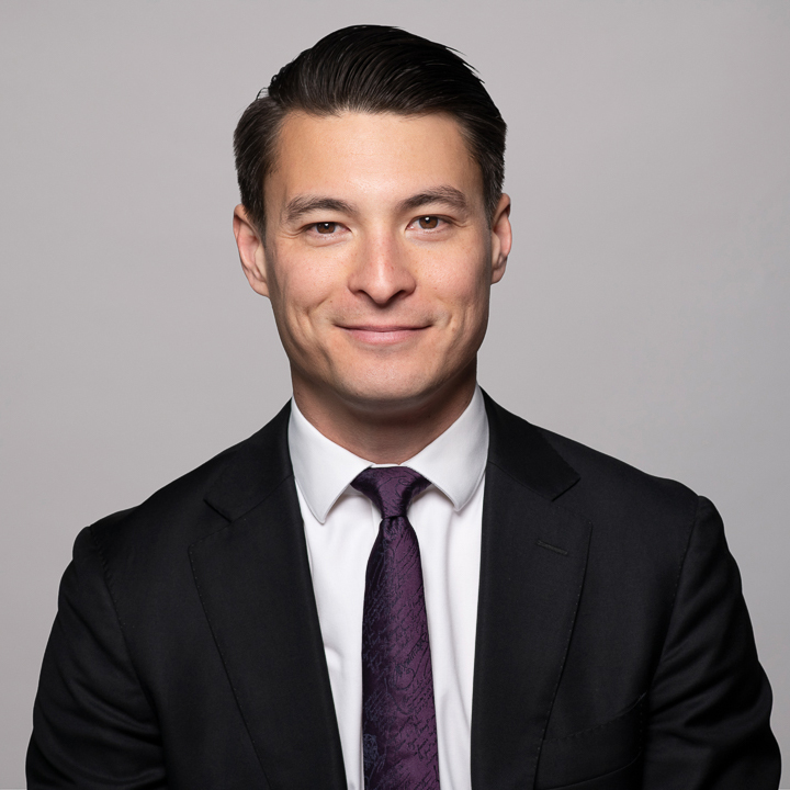 Melbourne LinkedIn headshot for local barrister, dressed in a suit with a deep purple tie. He is smiling to camera.